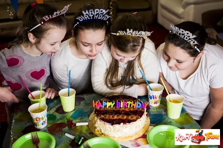 A group of happy 7-year-olds wearing racing suits and helmets.