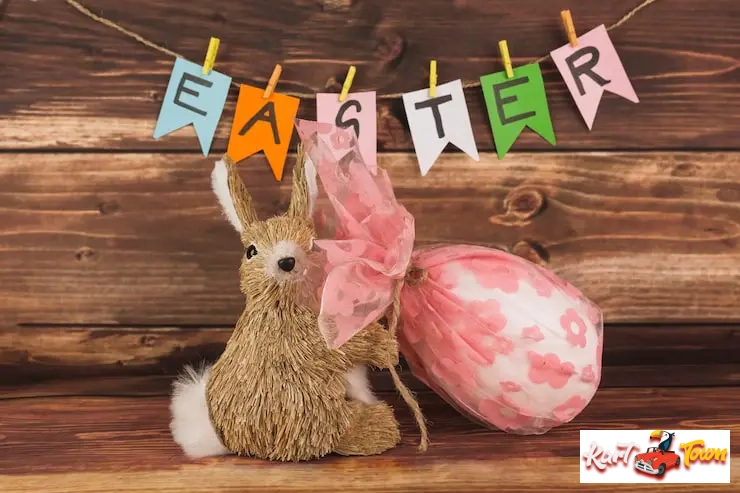Straw bunny and pink wrapped egg decor with a hanging banner.