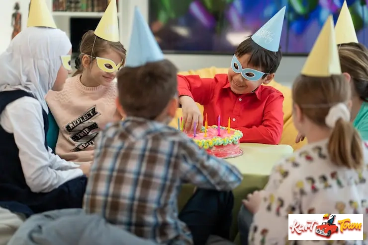 Kids in party hats and masks gathering around a colorful birthday cake.