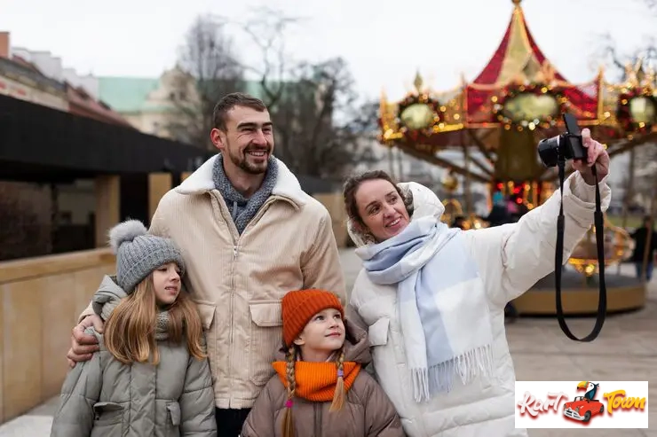 Family taking a selfie by a winter carousel.