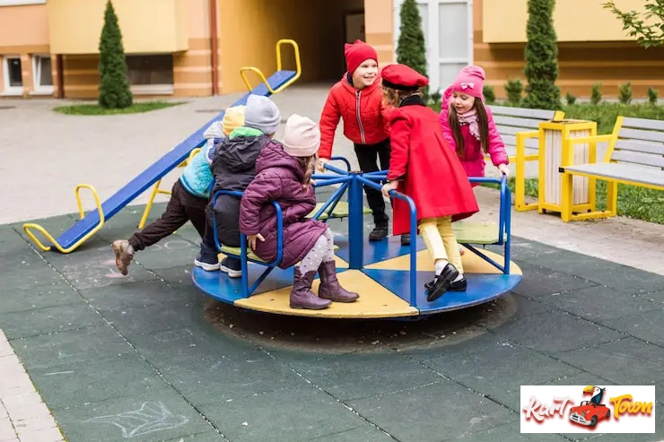 Group of children playing on a colorful merry-go-round.
