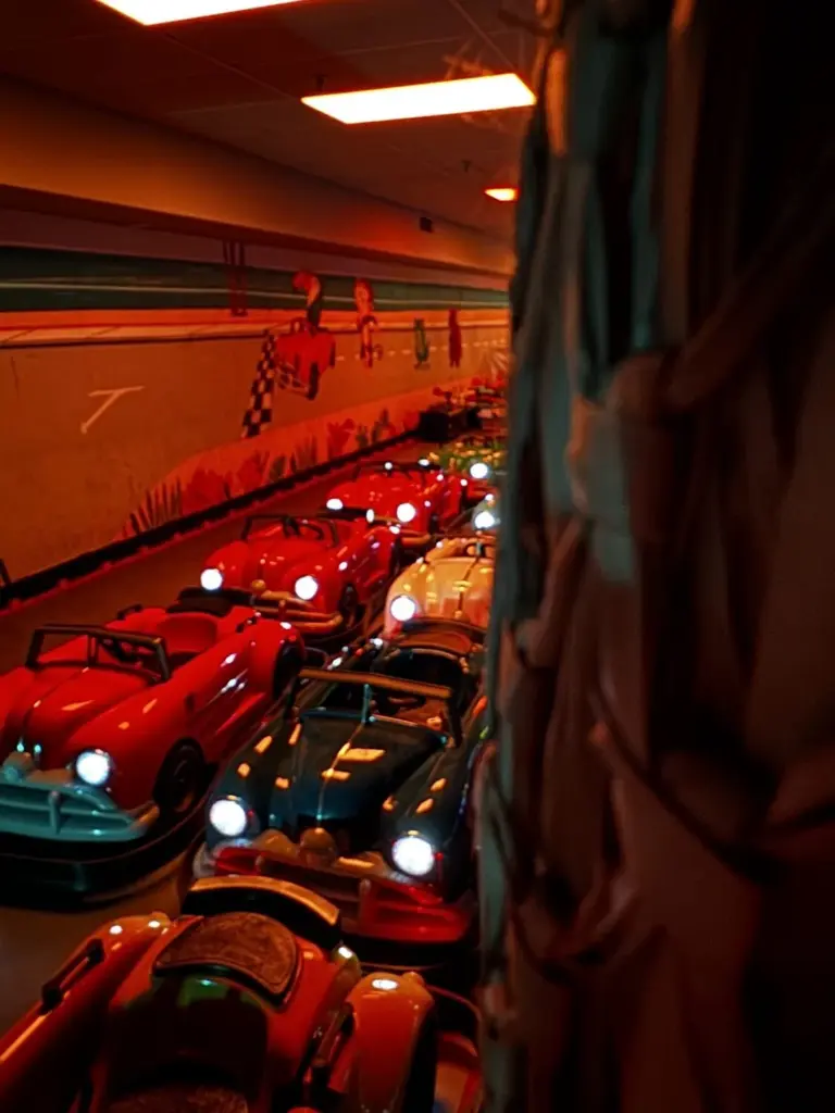 Lineup of retro classic cars with headlights on at Kart Town
