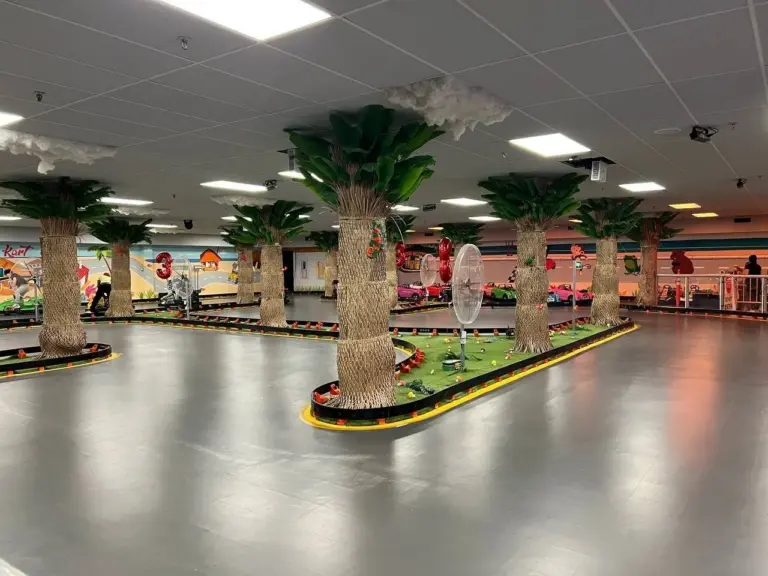 Tropical indoor go-kart track with palm trees at Kart Town