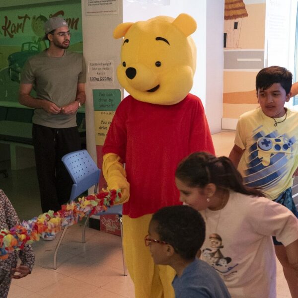 Friendly mascot meeting children at the anniversary event