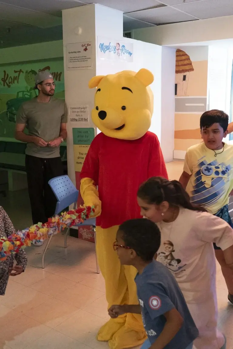Friendly mascot meeting children at the anniversary event