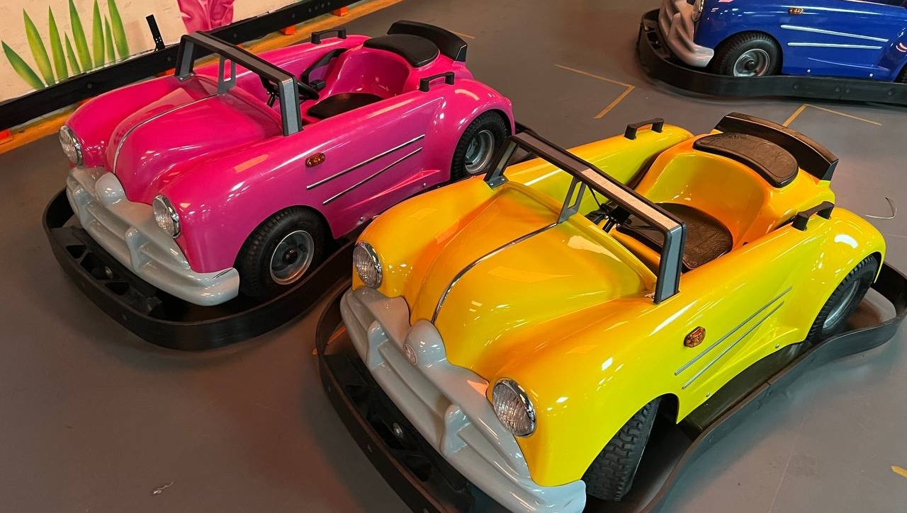 Pink and yellow classic ride-on cars parked ready for kids to drive