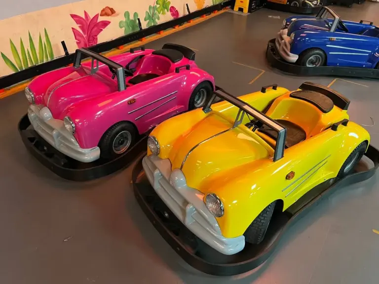 Pink and yellow classic ride-on cars parked ready for kids to drive