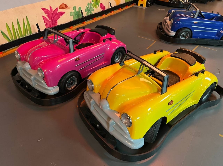 Pink and yellow classic ride-on cars parked ready for kids to drive