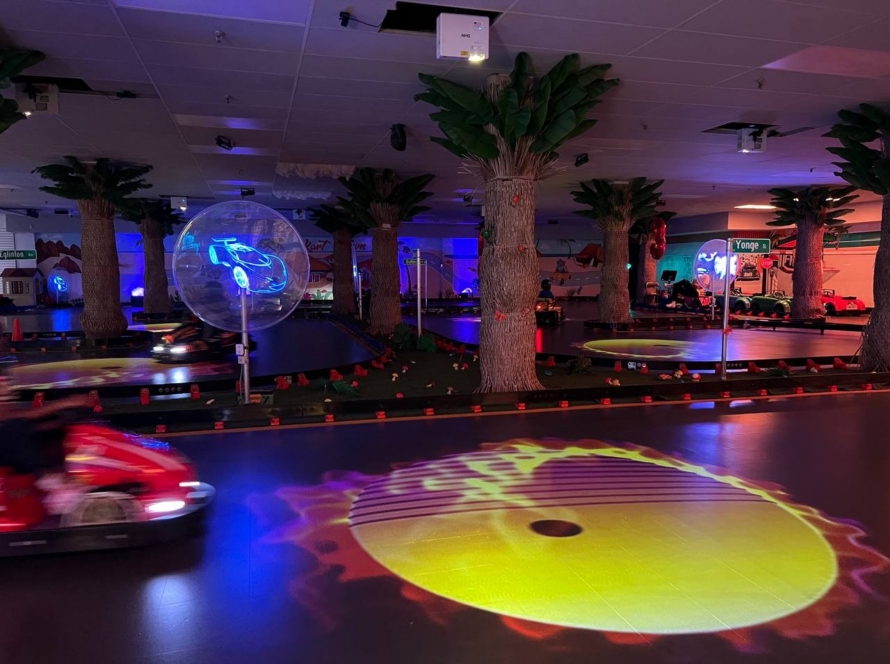 Kart Town track at night with UV lighting, blue race car projection and glowing yellow effects