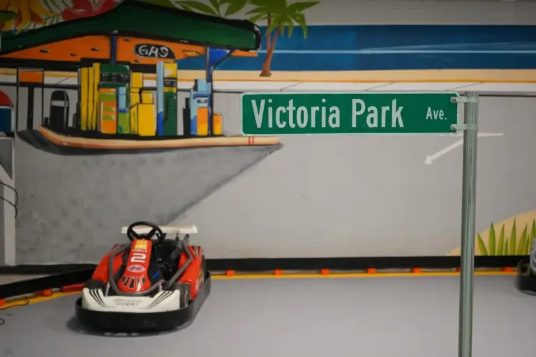 Go-kart beside the themed gas station prop on the indoor track