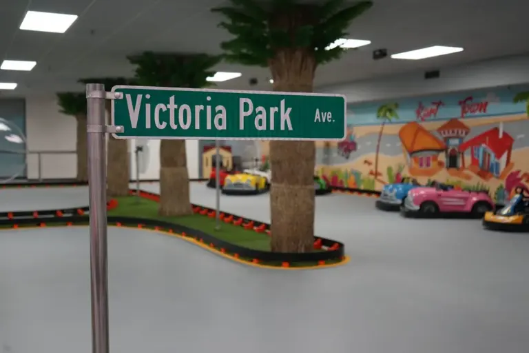 Bright wide view of the indoor go-kart track at the Victoria Park sign