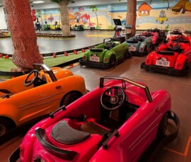 Little drivers love cruising the classic car ride past our palm-tree track. Children riding the classic cars past the palm-tree track
