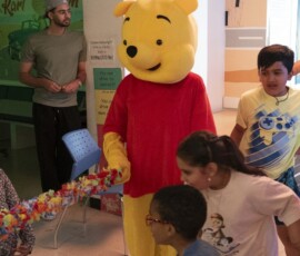 Our friendly mascots joined the fun for hugs and photos. Friendly mascot meeting children at the anniversary event
