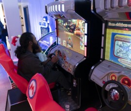 Take a seat in our Mario Kart riding cabinets — fun for kids and grown-ups together. Parent and child riding a Mario Kart arcade cabinet with a steering wheel at Kart Town Aurora