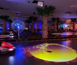 Blacklight glow, projected effects and karts in motion — our track after dark is a whole new experience. Kart Town track at night with UV lighting, blue race car projection and glowing yellow effects