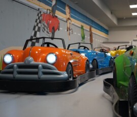 Headlights on and ready — line up at the start and take your mark. Go-karts with headlights on lined up head-on at the start of the indoor track