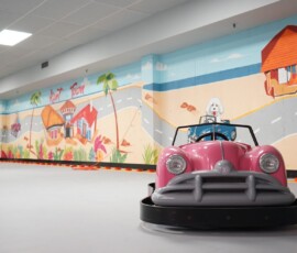 Cruise in style behind the wheel of our retro pink kart. Pink classic-style go-kart facing the camera on the bright indoor track